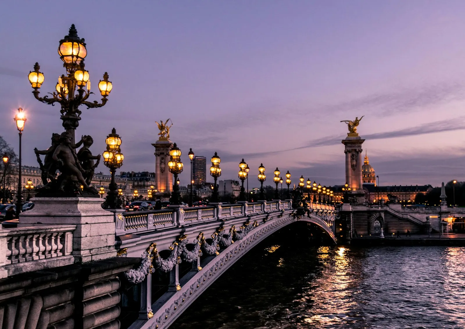 Paris bridge with illuminated lamps at dusk