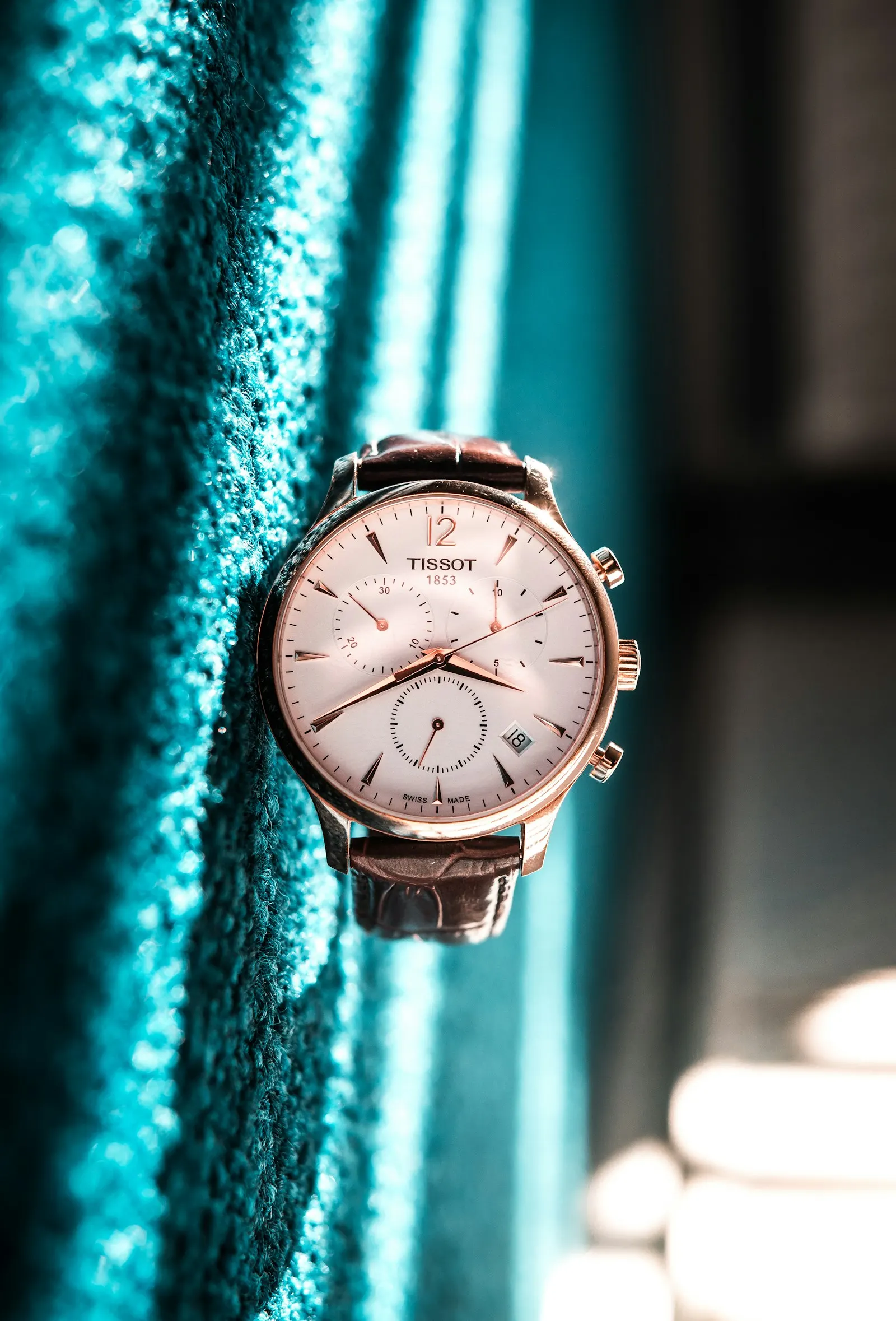 Wristwatch displayed against green fabric