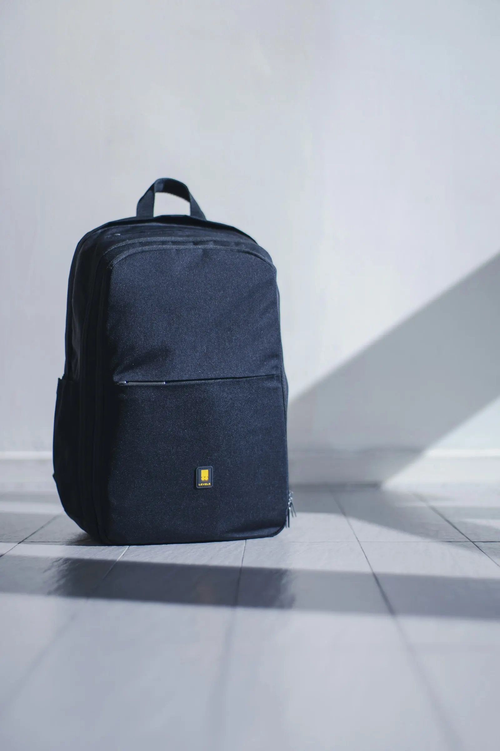 Dark backpack on a geometric background