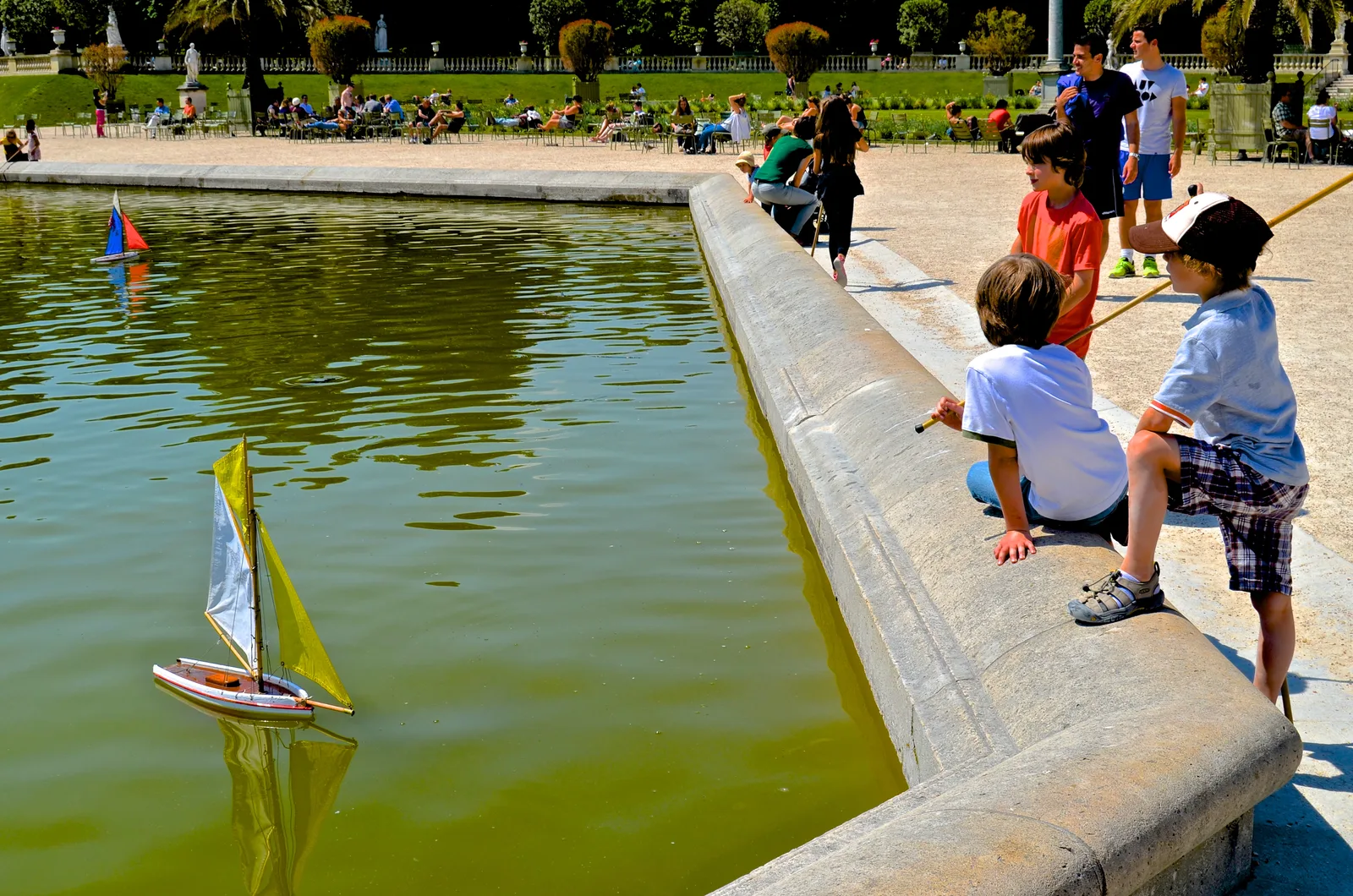 Children sailing model boats at the Luxembourg Garden pond in Paris in May 2014