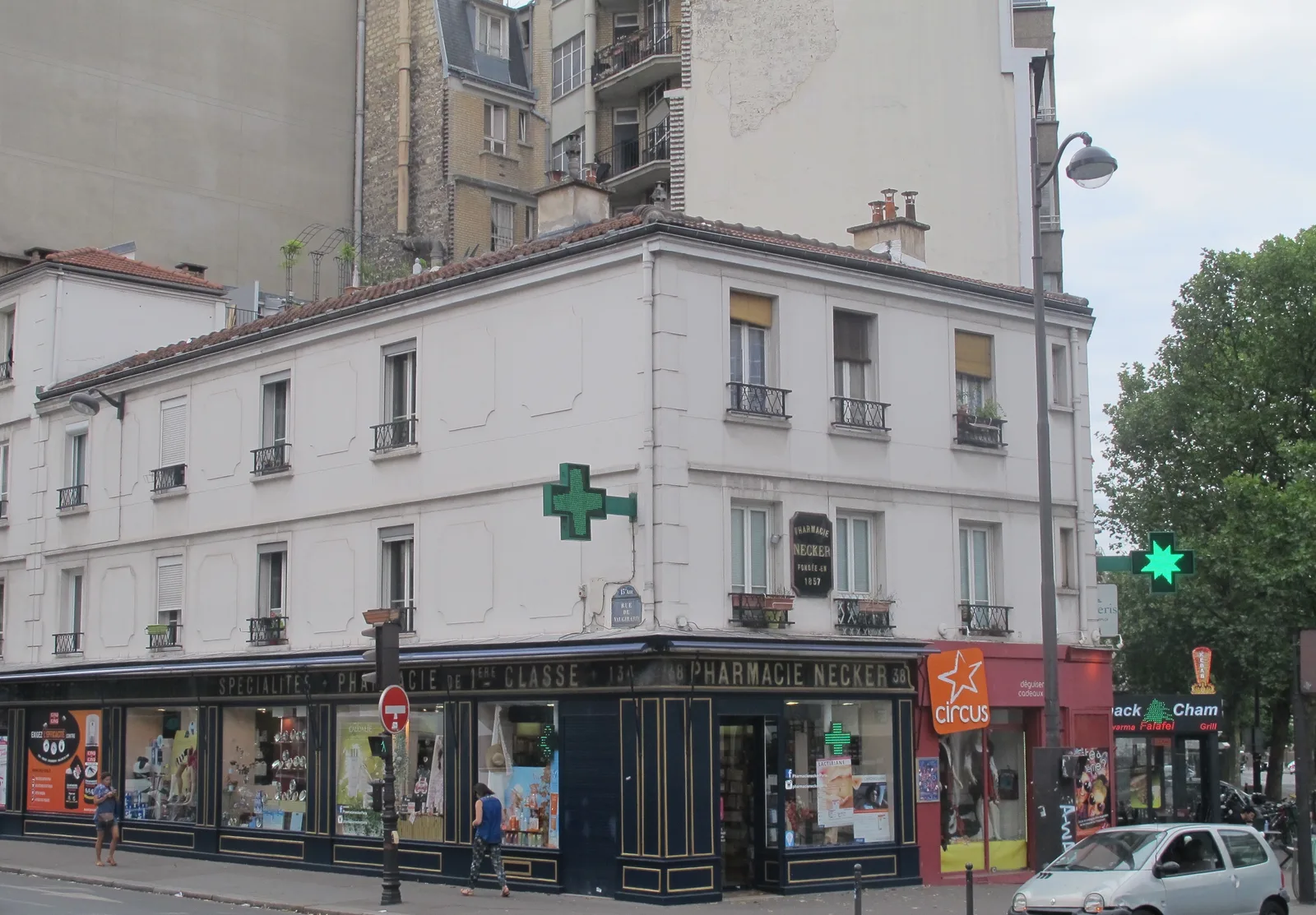 The façade and green crosses of Pharmacie Necker in Paris in July 2017; not current opening information